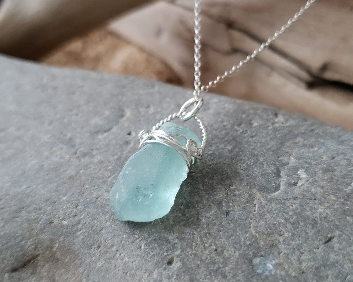 Aqua Blue Beach Glass Serenity Pendant Necklace, on stone background