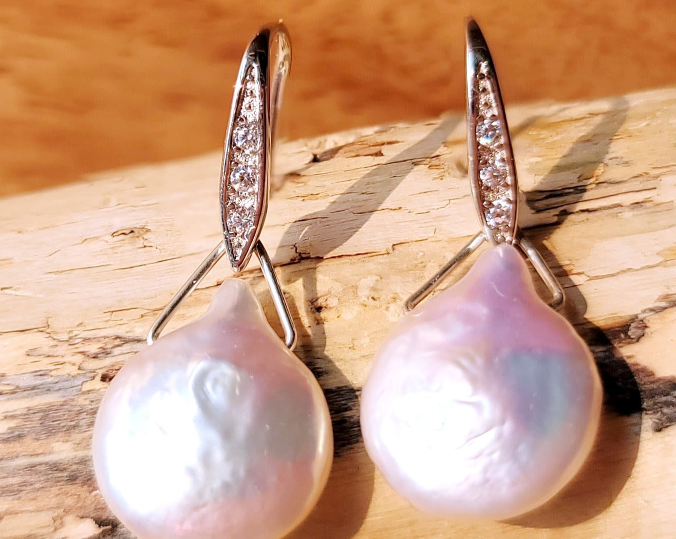 Large White Baroque Pearl Earrings, Large white, drop shaped, almost coin shaped pearls danglin from a Cubic Zirconia encrusted french earrings hooks.  . 