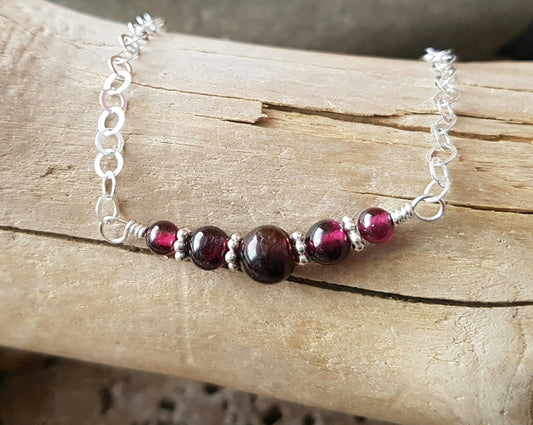 Royal Garnet Curved Beaded Bar Necklace with graduated pinkish Garnets and Sterling Silver decorative beads on sparkly flat cable link chain