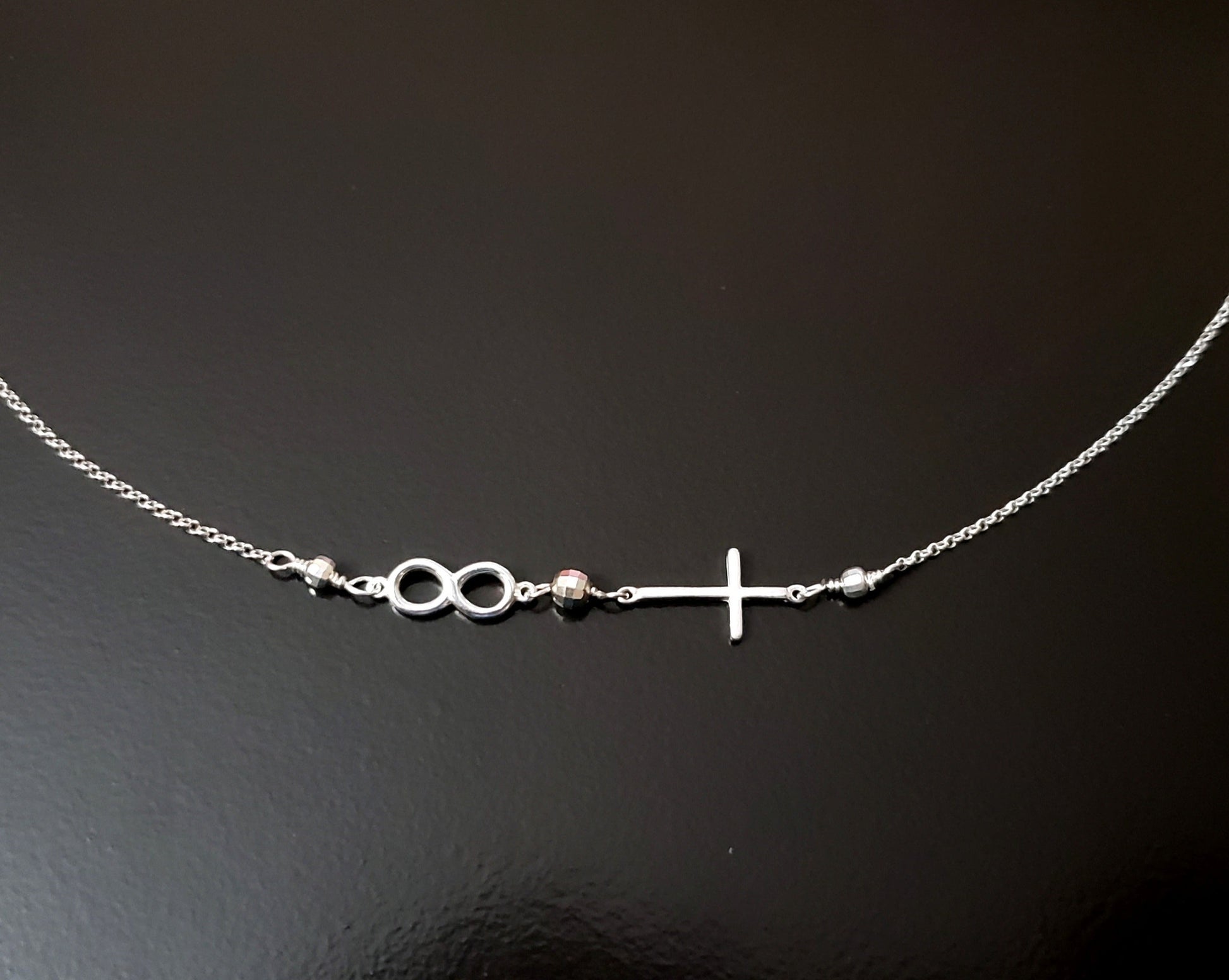 Infinite Faith Sideways Cross Infinity Necklace with an Infinity Pendant and Cross attached to chain with sparkly beads. 