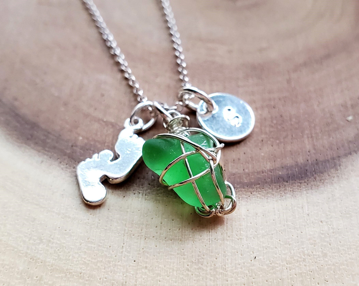 Personalized Footprints in the Sand Green Beach Glass Necklace, made with Sterling Silver, an Initial Pendant, Footprints pendant and a wire wrapped green Beach Glass pendant. 